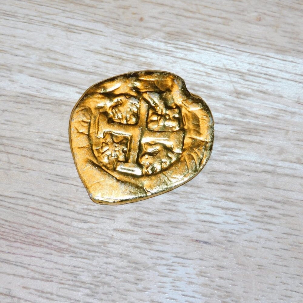 The Goonies movie gold coin prop replica from Onr Eyed Willy's pirate treasure